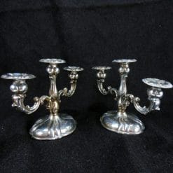 Coppia di candelabri in argento a tre fiamme antichi, sagomati e cesellati in stile barocco. Per amanti del binomio modernariato e argento.