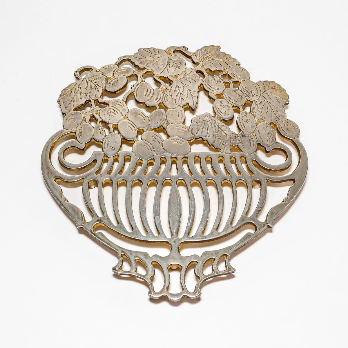 Elegante sottopentola Piero Maestri anni '80 in metallo, con design di viti e uva. Ottime condizioni, perfetto per collezionisti di design vintage.